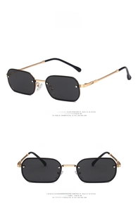Detail of vintage hexagonal sunglasses featuring gold metal frames and grey lenses