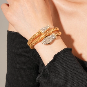 Detail shot of golden double-wrap snake bracelet with sparkling white crystal accents