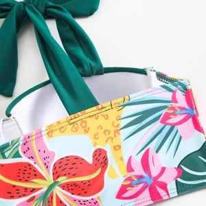 Detail of tropical floral print and halter neck strap on a mesh beach swimsuit