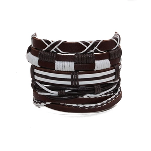 Macro shot of 5-piece multilayer braided leather and wax cord bracelet set on white