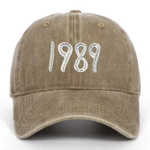 Detailed view of white 1989 embroidery on a vintage washed cotton brown baseball cap