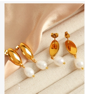 Macro shot of 18K gold crescent post earrings with white teardrop freshwater pearls