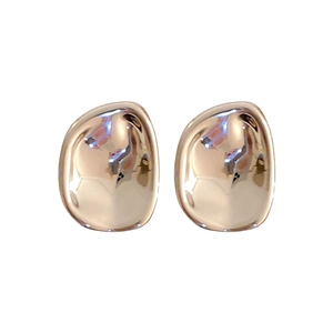 Irregular golden bean stud earrings with polished metallic luster on white background