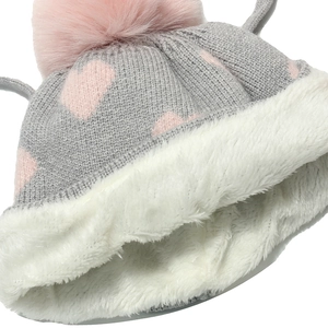 Detail of warm grey knit hat with pink heart patterns and thick white fleece lining
