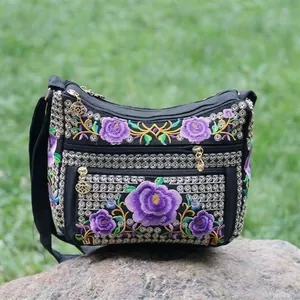 Close-up of ethnic style black canvas bag featuring purple peony embroidery and sequins