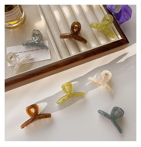 Selection of multi-colored translucent 4.5cm hair claw clips on a wooden tray