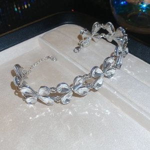 Detail of silver bracelet with crystal butterfly charms inside a beige jewelry gift box