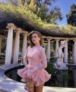 Close-up of pink ruffle slim fit dress paired with a sparkling glitter handbag