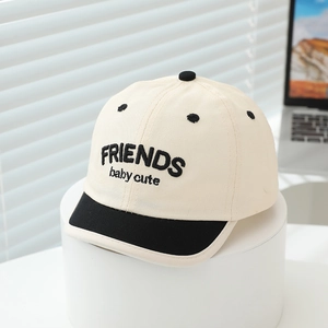 Detail of baby baseball cap with Friends embroidery on a white display stand