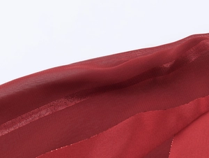 Detailed macro view of dark red striped semi-transparent fabric with subtle shimmer texture