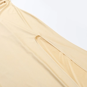 Détail macro de la fente latérale haute et du tissu abricot lisse de la robe ajustée