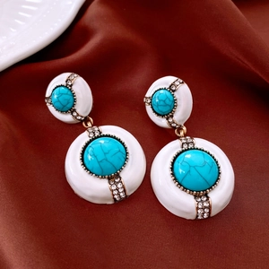 Gros plan détaillé de boucles d'oreilles vintage en bronze avec turquoise et strass brillants