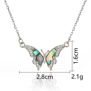 Detailed macro view of silver butterfly pendant with shell inlay and cubic zirconia