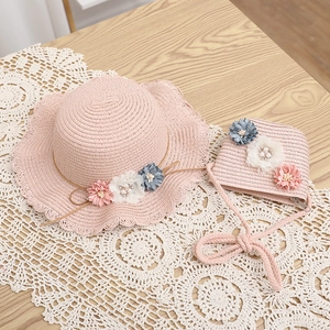 Dettaglio del set cappello e borsa in paglia rosa con tre fiori e bordo a onde