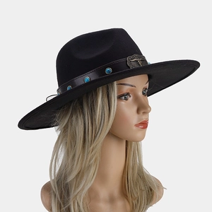 Detail of black felt fedora featuring leather band with turquoise studs and bull head