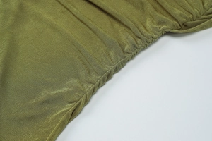 Detailed close-up of olive green ribbed fabric with pleated stitching on a slim dress