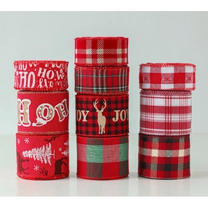 Close-up of stacked Christmas ribbons featuring snowflakes and plaid patterns on burlap
