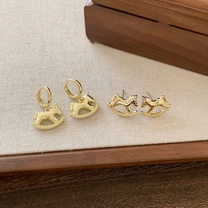 Close-up of 18k gold plated rocking horse earrings with retro hammered texture