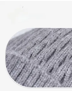 Close-up of gray winter hat showing thick knitted texture and windproof material layers