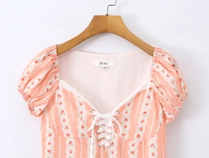 Dettaglio del top a fiori rosa con scollo quadrato, pizzo e design con lacci frontali