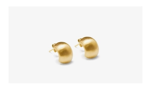 Detail of matte 18K gold plated thick C-shaped hoop earrings with satin finish texture