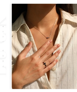Gros plan d'un ensemble bijoux croix en argent S925 avec pierres bleues sur un modèle