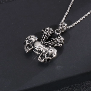 Close-up of a silver skull engine pendant with twist chain and metallic texture
