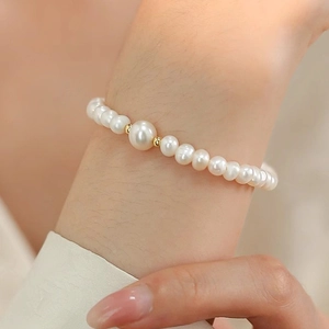 Close-up of a freshwater pearl bracelet with gold accents on a woman's wrist