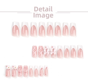 Detail view of pink French press-on nails with 3D bows, pearls and flower decorations