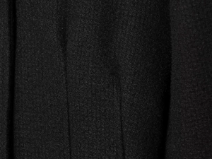 Close-up of black wool-blend fabric texture showing premium fiber details on a blazer