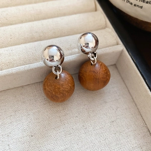 Macro des boucles d'oreilles boules argentées et pendentifs géométriques bois marron