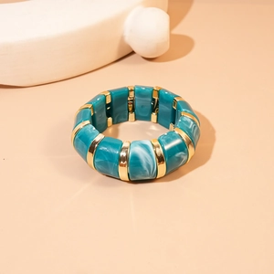 Macro detail of turquoise marble resin bracelet with gold metallic dividers and texture