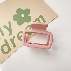 Detail of pink matte square hair claw clip with internal teeth on floral card