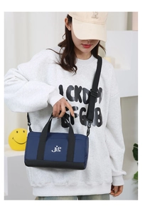 Detail of the navy blue nylon crossbody bag with JLP logo and black adjustable strap