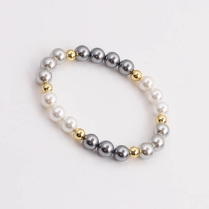 Elegant beaded bracelet featuring white and grey pearls with gold metallic accents