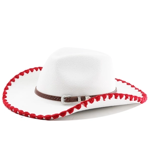 Détail du chapeau de cowboy blanc en feutre avec bordure à pompons rouges et ceinture marron