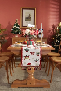 Close-up of Christmas table runner with festive bell and snowflake patterns and tassels