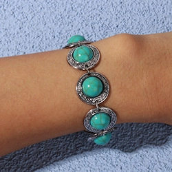 Close-up of vintage bohemian bracelet featuring turquoise stones on a silver metal band