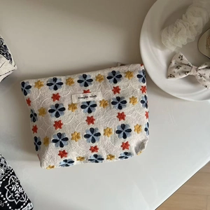 Detailed embroidery of colorful flowers on cotton canvas cosmetic bag with simple wish tag