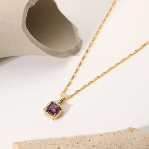 Detailed macro view of 18k gold chain necklace with square purple zircon pendant
