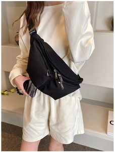 Detail of a black nylon crossbody bag with multi-zipper pockets and wide shoulder strap