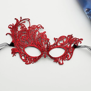 Detail of red lace embroidery mask with hollow pattern and black satin ribbons