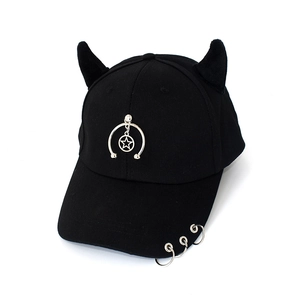 Detail of punk style black baseball cap with silver metal rings and star pendants