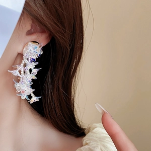 Detailed view of colorful floral tassel earrings with pearl bead accents on a model