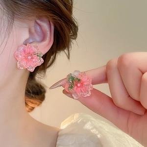 Detailed view of sweet pink flower earrings with green leaf accent and resin texture