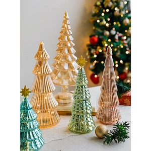 Elegant glass Christmas tree decorations with gold stars and warm holiday glow