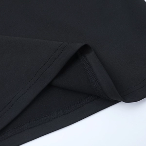 Detailed close-up showing double-needle stitching on black knitted fabric hemline