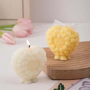 Macro detail of heart-shaped rose candles with Love engraving on a wooden base