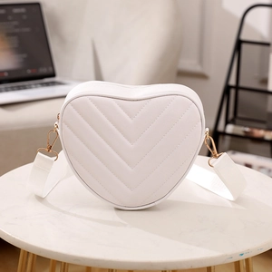 White heart-shaped crossbody bag with V-quilted texture and gold-tone metal hardware
