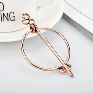 Macro shot of vintage bronze Viking brooch with snake-shaped needle on book background